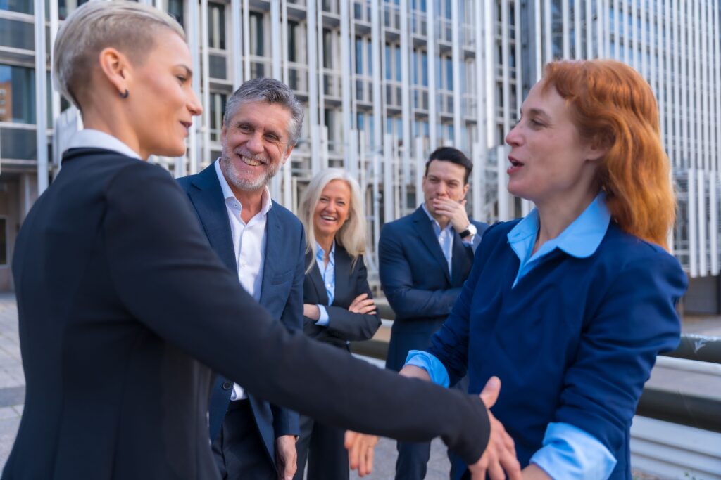 Group of business professionals having a conversation outside a modern office building