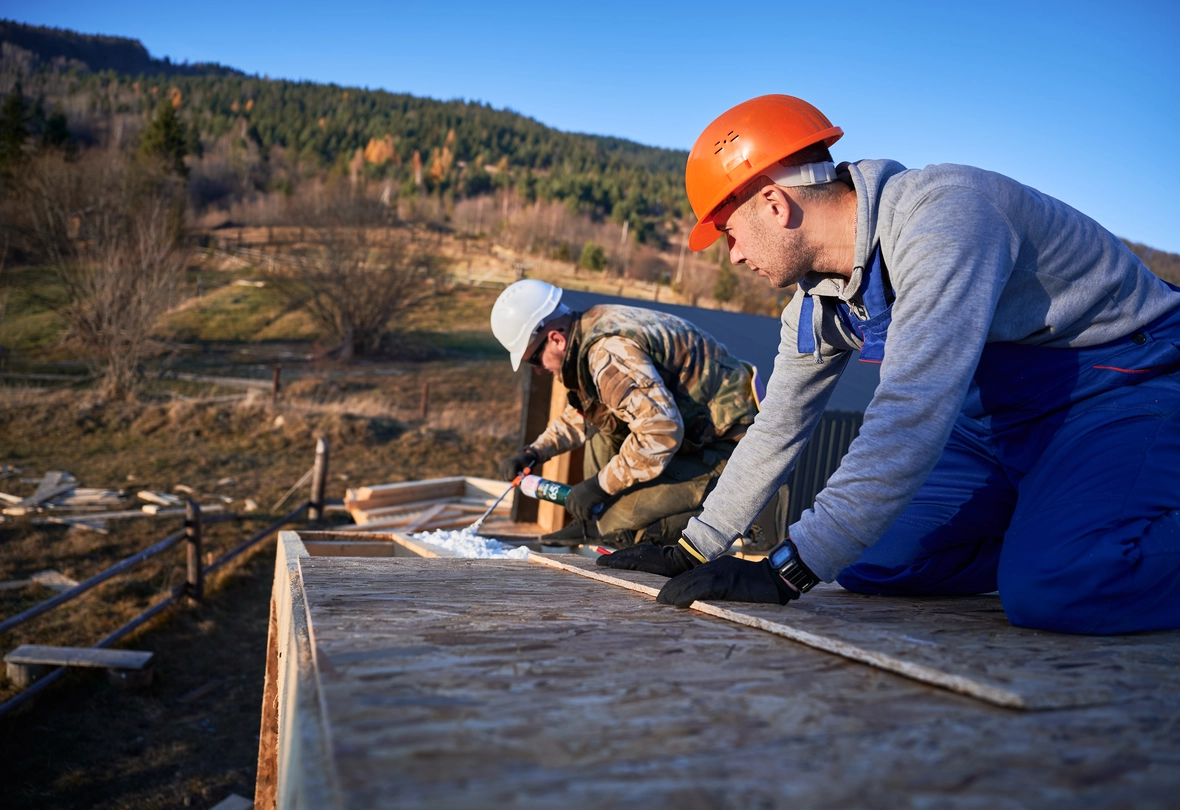 male builder doing thermal insulation on roof